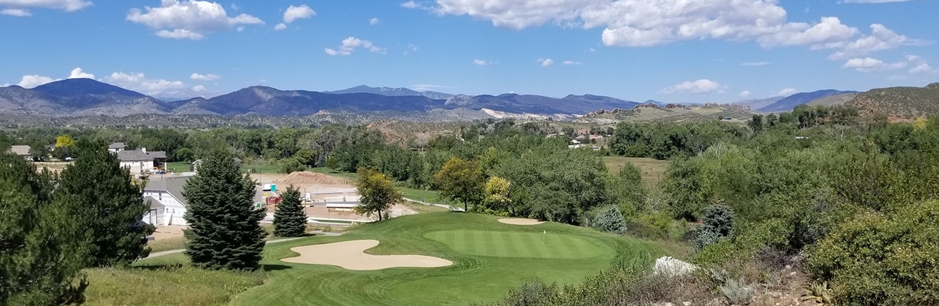 Photo taken by Colorado photographer, Bill Bleich of a fairway and putting green on a golf course with a beautiful view of the mountains.